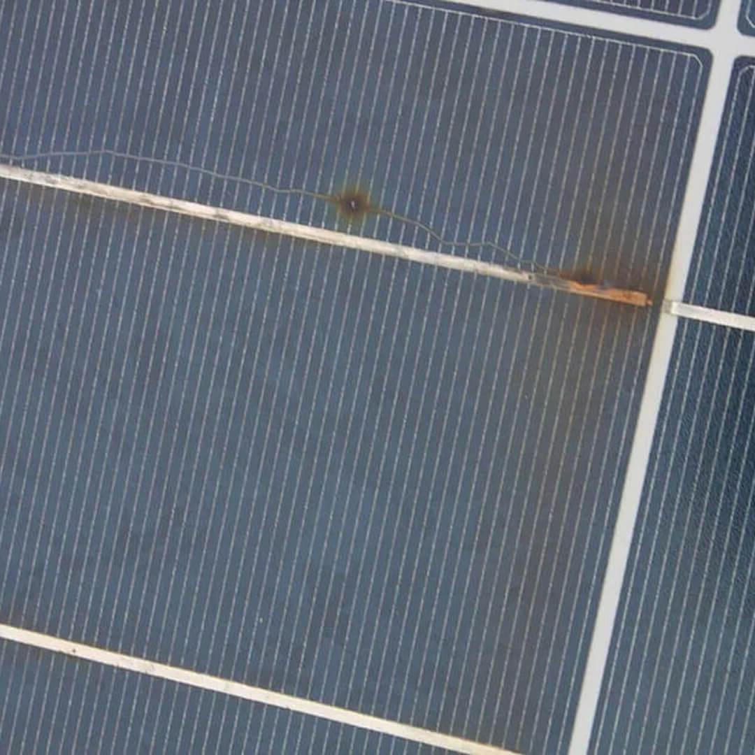 A solar panel with a rusty nail protruding from it, posing a potential hazard to the panel's functionality.